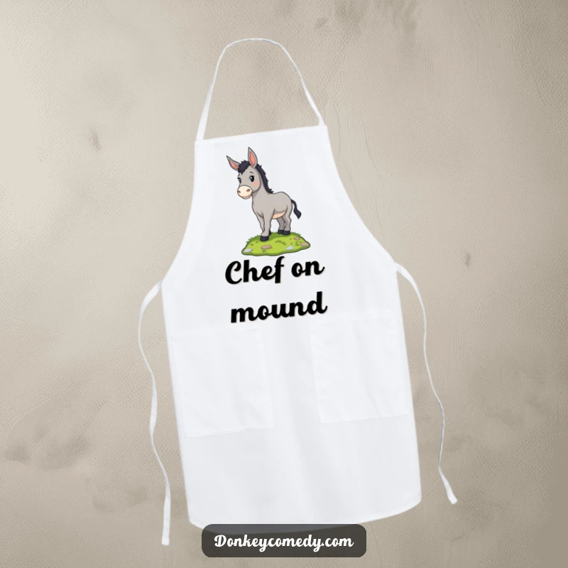 Funny proud donkey standing on a grassy mound, on a kitchen apron, a humorous and practical gift.