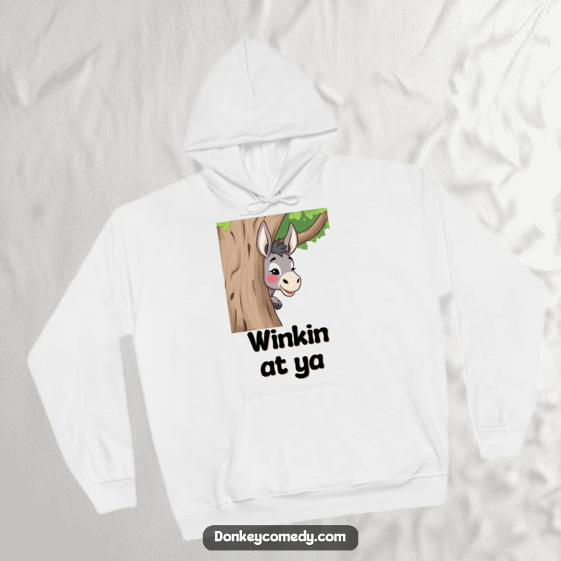 Funny donkey hoodie showing a donkey playfully peeking from behind a tree with a mischievous wink, perfect for cozying up.