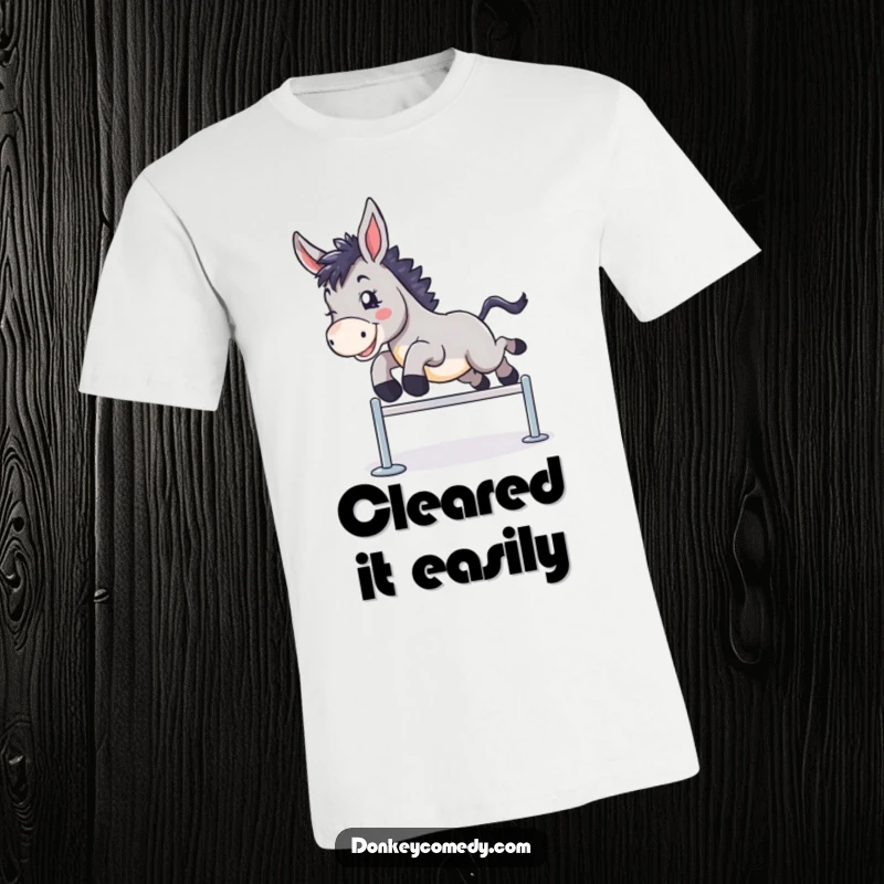 Funny t-shirt depicting a donkey enthusiastically clearing a small hurdle with a triumphant and joyful expression.
